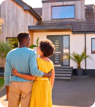 Couple vue de dos devant leur maison – Acquisition de résidence principale ou secondaire – Assurance emprunteur