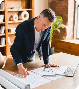 Dirigeant professionnel penché sur son bureau – Revenus variables – Placements financiers professionnels
